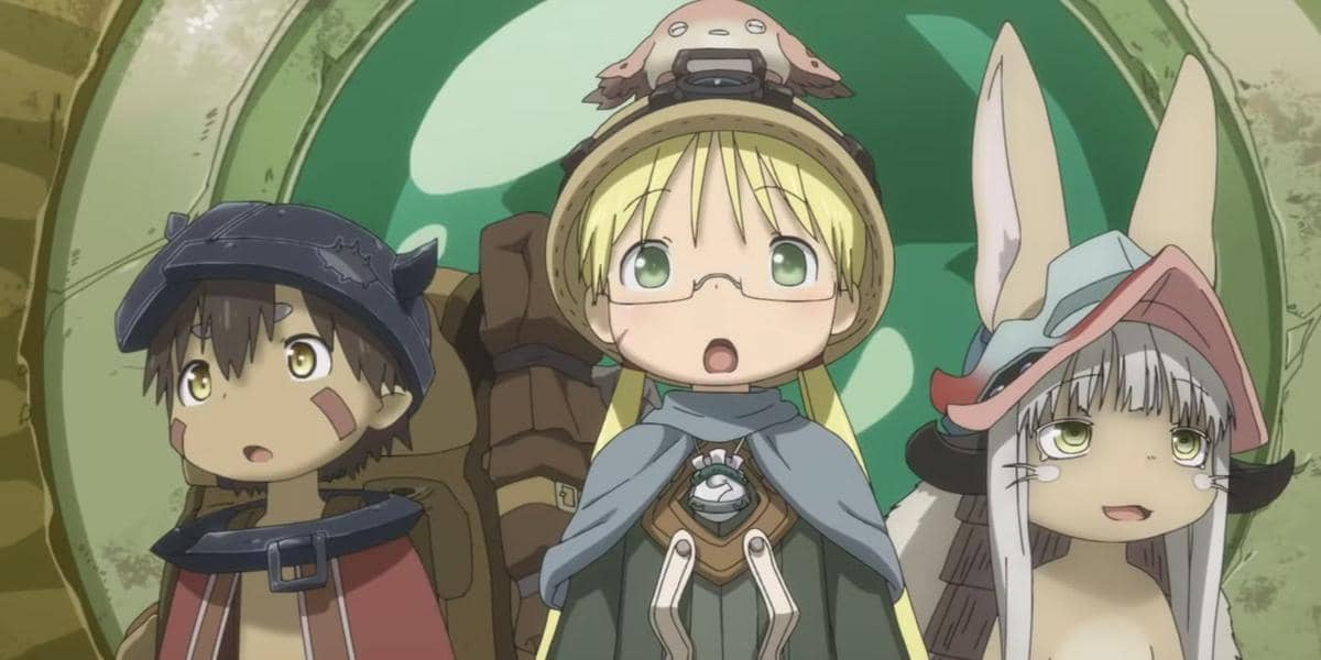 Tiga karakter anime Made in Abyss berdiri berdampingan dengan ekspresi takjub di depan latar berwarna hijau dan emas.