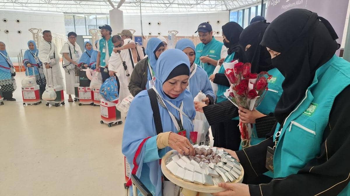 Petugas Kementerian Haji Arab Saudi membagikan souvenir, bunga mawar, dan cokelat kepada jemaah embarkasi KNO 17 di Bandara Jeddah.