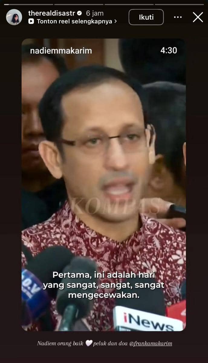Seorang pria mengenakan batik merah berbicara di depan mikrofon dari berbagai media saat memberikan pernyataan kepada pers.