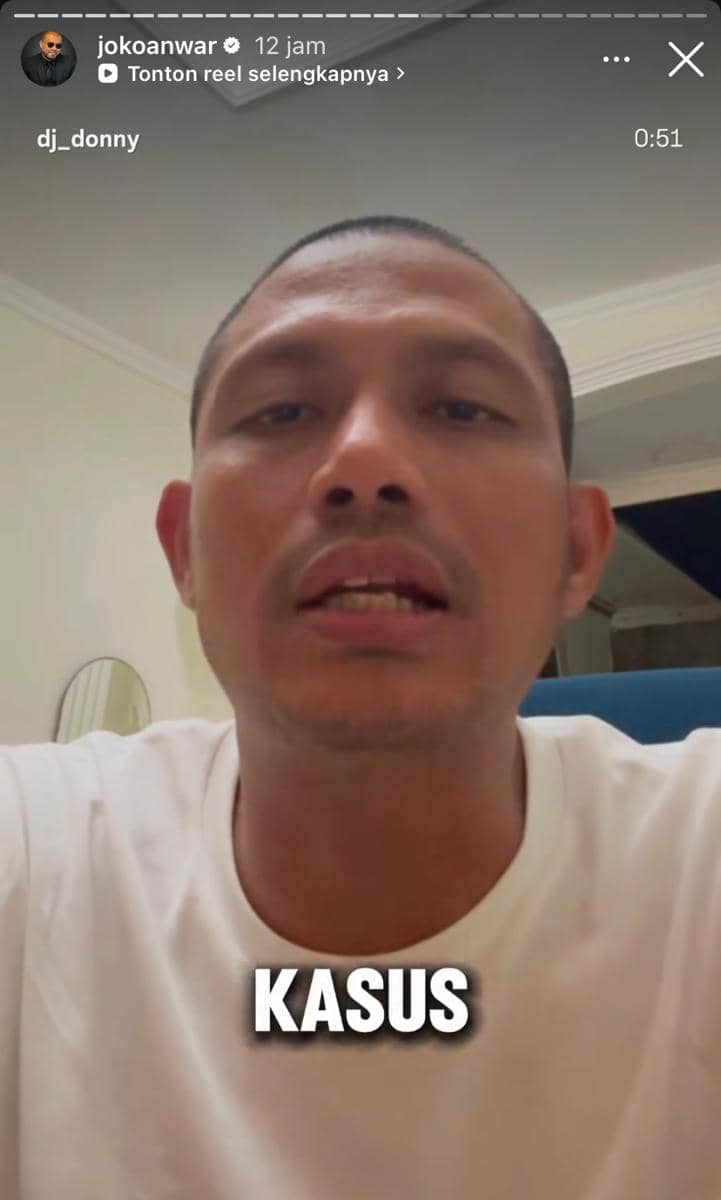 Seorang pria mengenakan kaus putih berbicara di depan kamera dalam video singkat dengan teks 'KASUS' di bagian bawah layar.