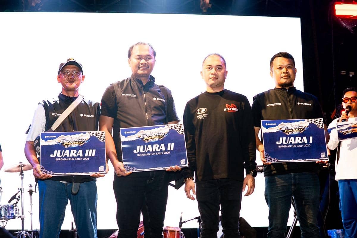 Para pemenang Burgman Fun Rally 2026 berpose di atas panggung sambil memegang papan penghargaan juara dari Suzuki.