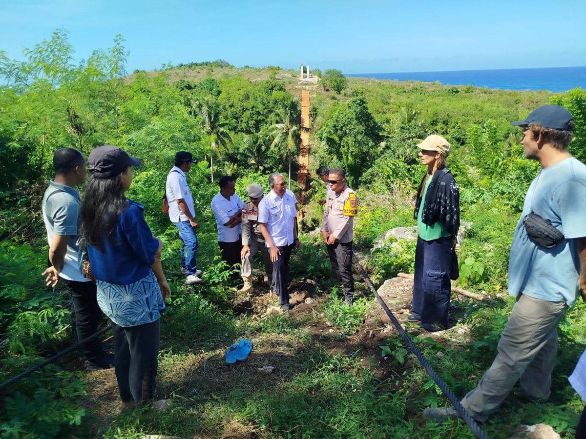 Sejumlah orang termasuk pejabat daerah meninjau lokasi proyek jembatan gantung yang roboh di kawasan hijau dekat pantai Sumba Barat.
