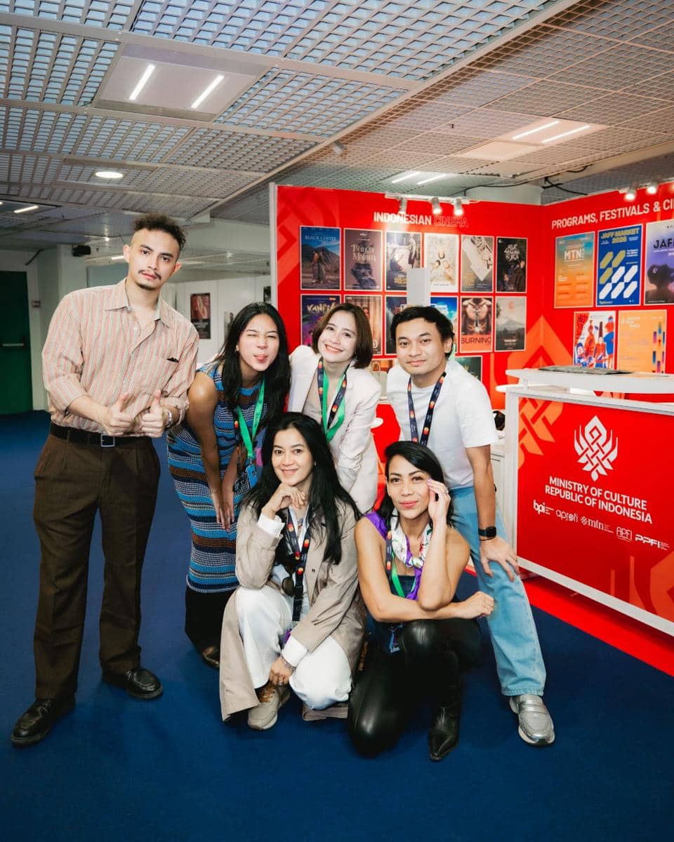 Lima orang berpose bersama di stan Kementerian Kebudayaan Republik Indonesia di Cannes Film Festival 2026 dengan latar poster film Indonesia.