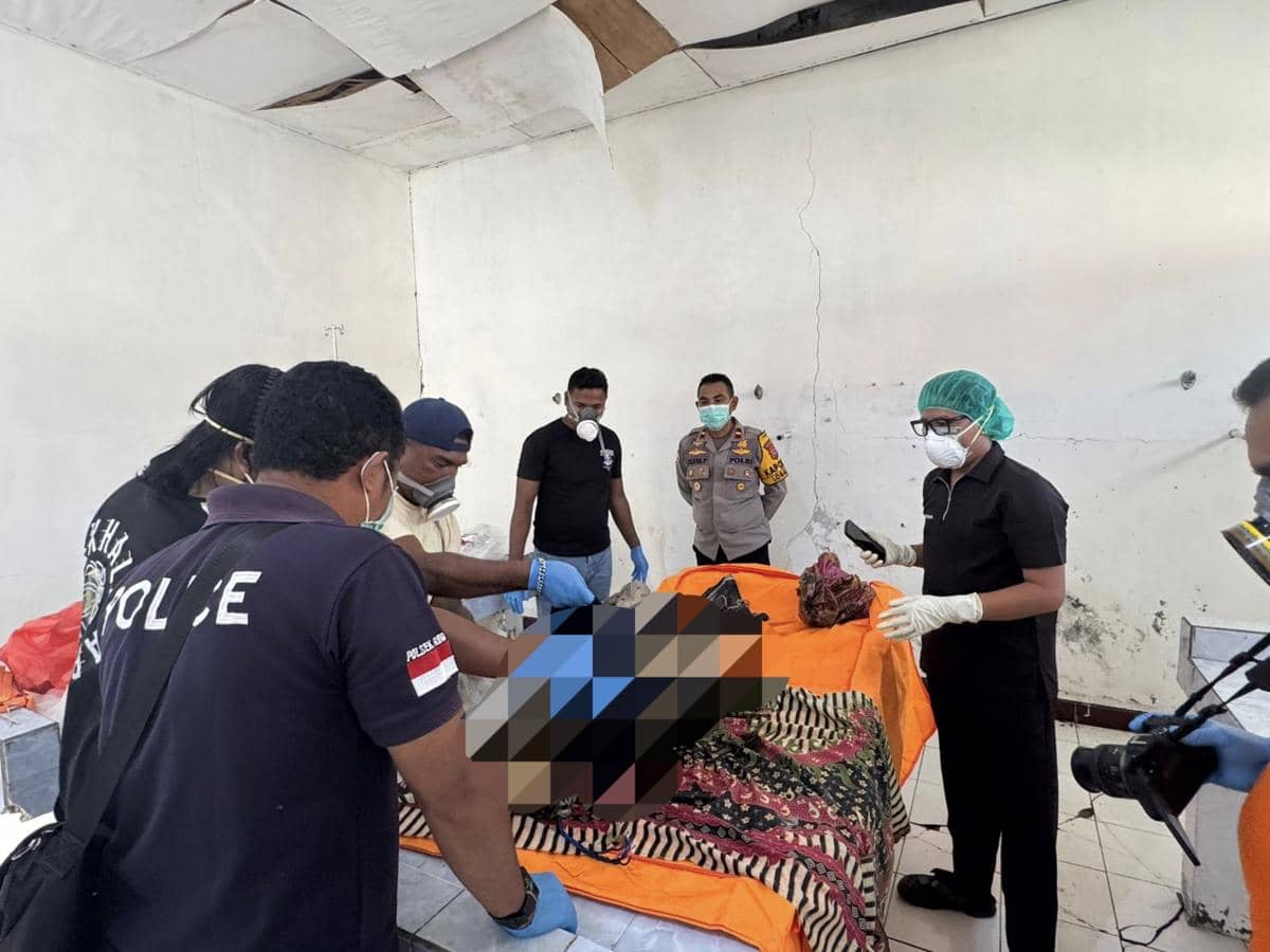 Petugas kepolisian dan tim medis memeriksa jasad yang ditemukan warga di Rote, ditutupi kain dan berada di atas meja pemeriksaan.