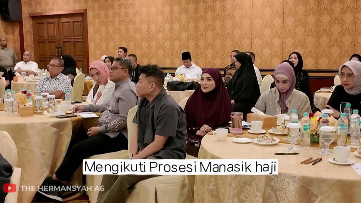 Sejumlah peserta duduk di meja bundar menghadiri acara manasik haji di sebuah ruangan dengan dekorasi dinding berwarna emas.