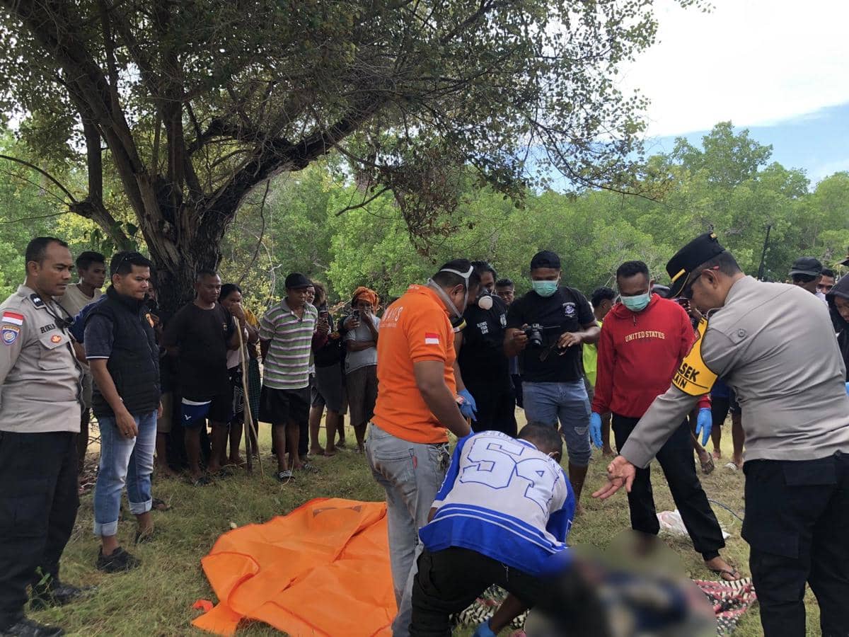 Petugas kepolisian dan warga berkumpul di tepi hutan bakau Rote saat mengevakuasi jasad yang ditemukan di lokasi kejadian.