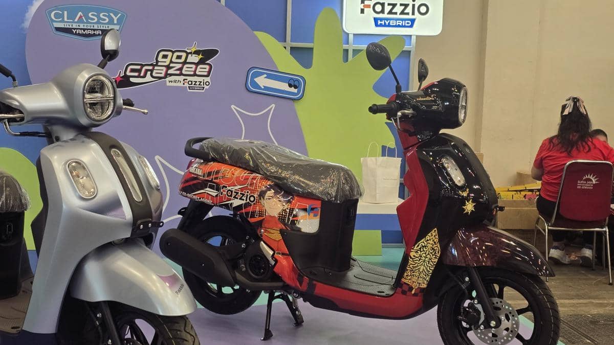 Dua motor Yamaha Fazzio dipamerkan di acara Comifuro 22 dengan desain unik dan latar booth berwarna cerah.