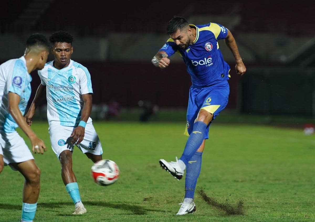 Pemain Arema FC menendang bola saat menghadapi PSBS Biak yang mengenakan seragam putih biru di Stadion Maguwoharjo.