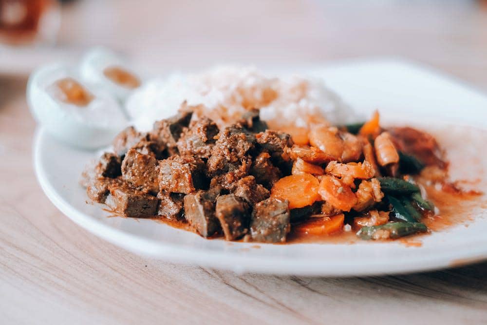 Sepiring tumis hati sapi dengan sayuran seperti wortel dan buncis disajikan bersama nasi putih dan telur rebus berisi kecap.
