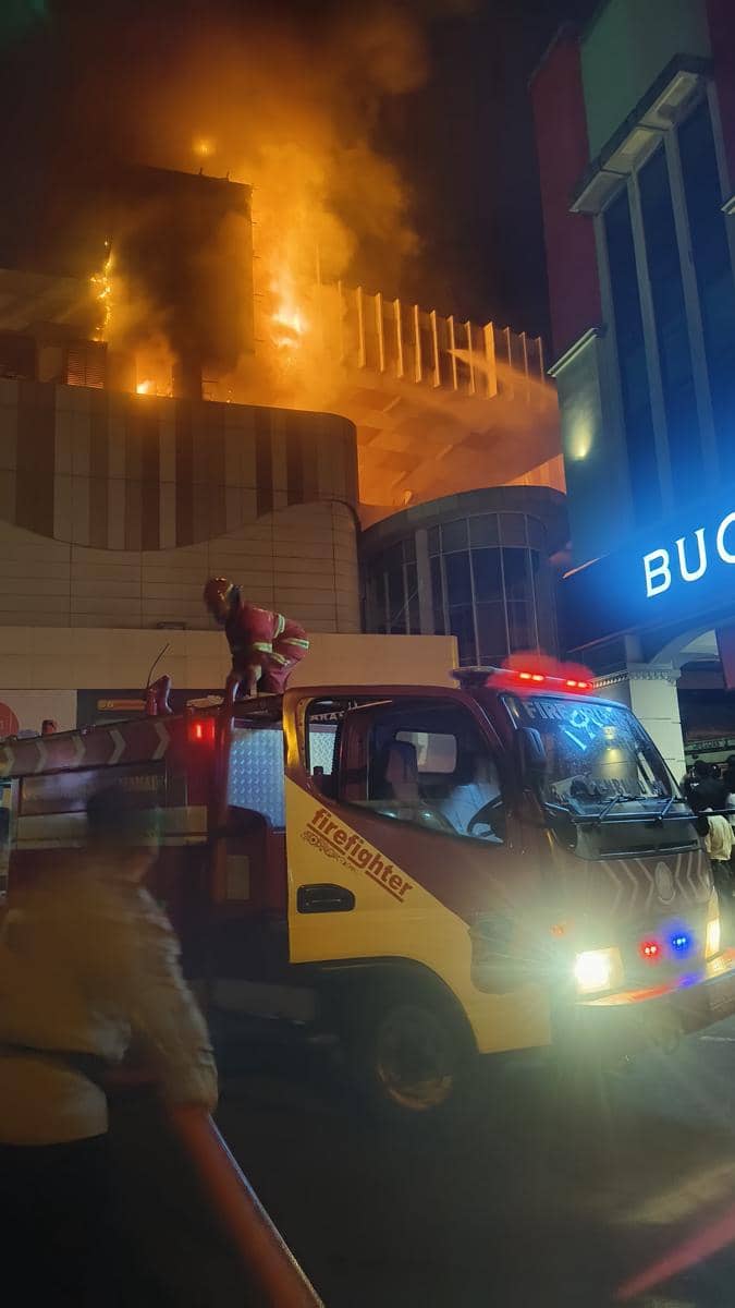 Petugas pemadam kebakaran berusaha memadamkan api besar yang melanda gedung Mega Mall Manado pada malam hari.