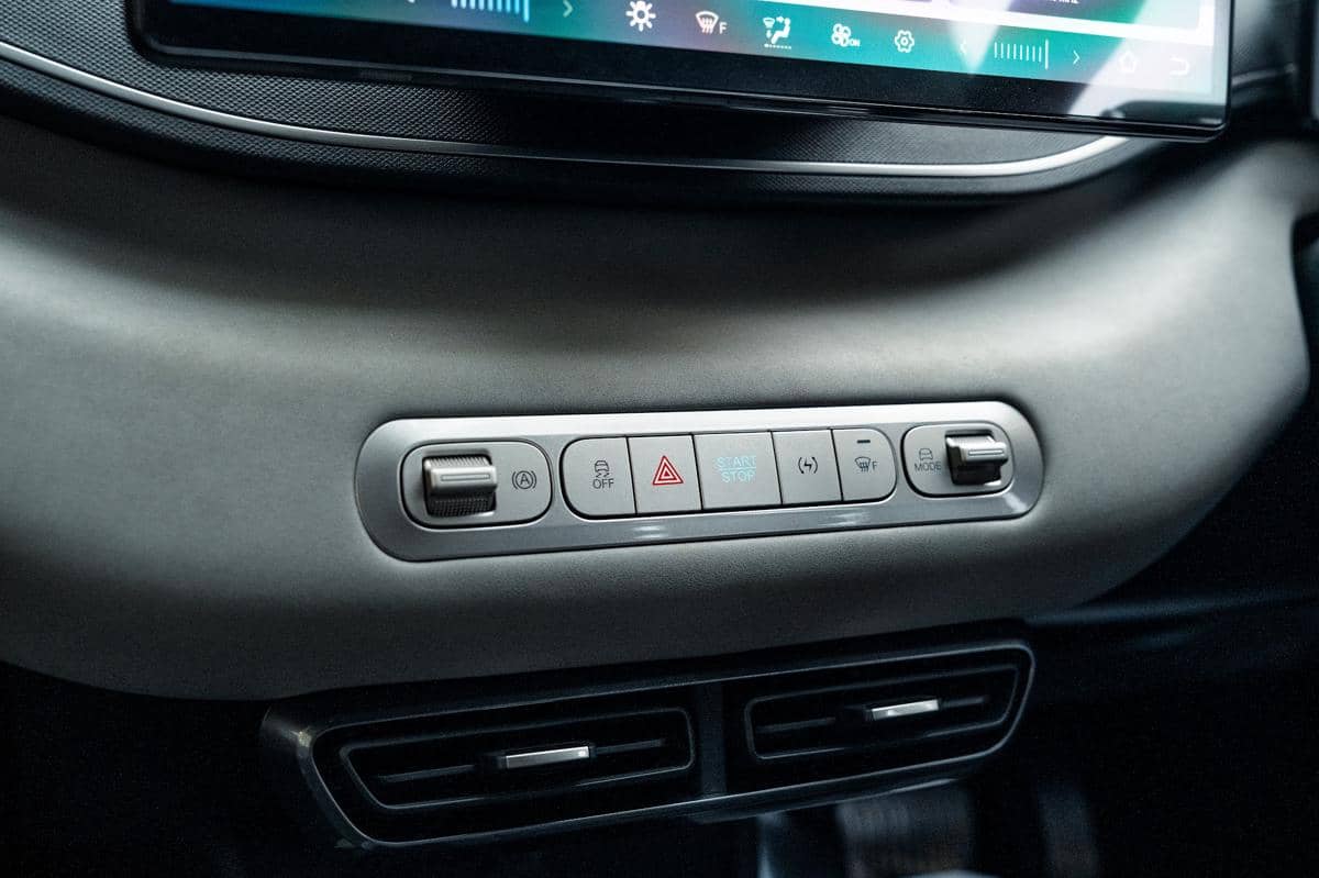 Panel kontrol interior mobil listrik BYD Atto 1 dengan tombol start stop, mode berkendara, dan fitur keselamatan di bawah layar sentuh.