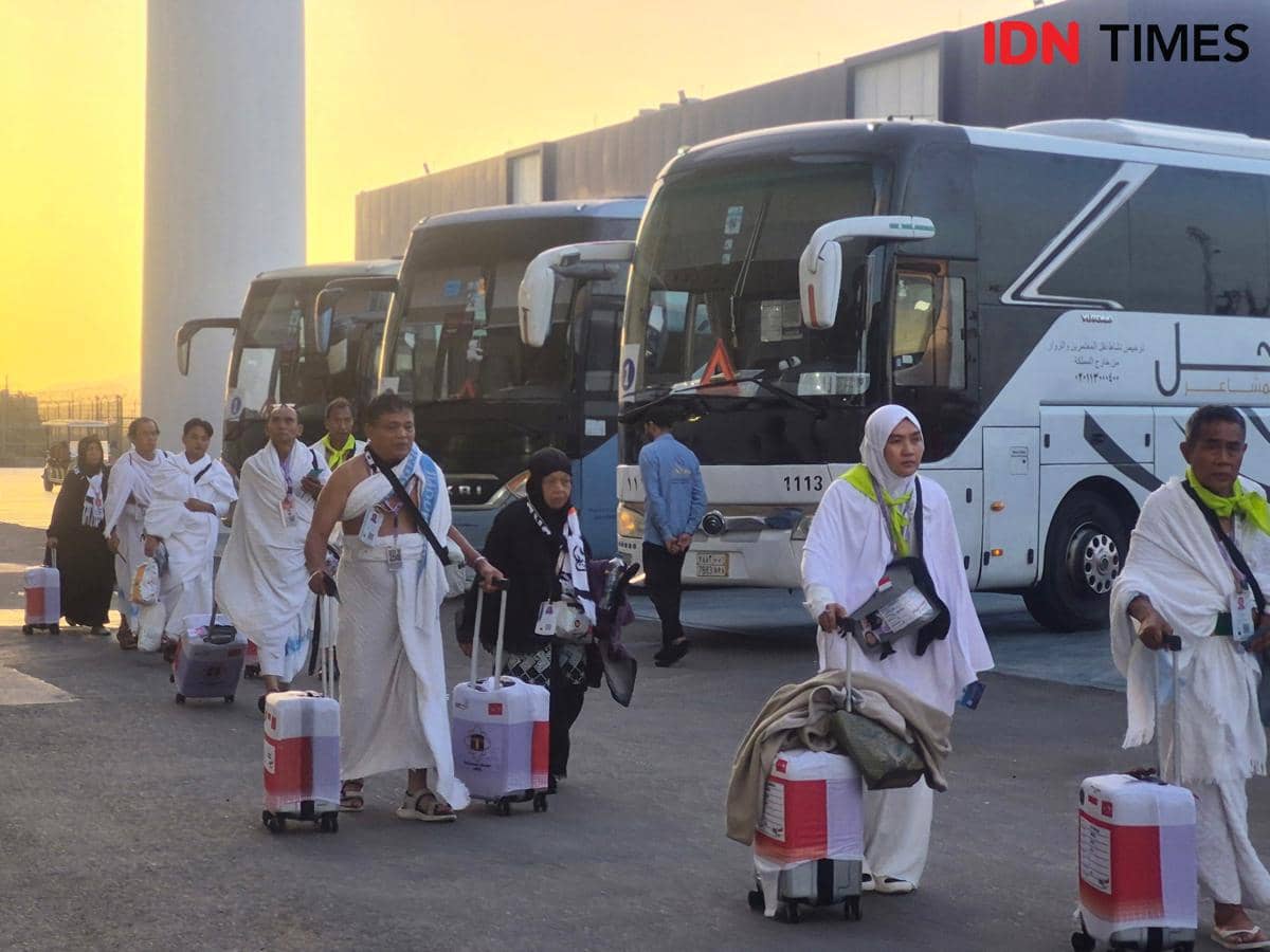 Jemaah haji embarkasi JKB 19 mengenakan pakaian ihram tiba di Bandara Internasional King Abdul Aziz dengan membawa koper kecil beroda.