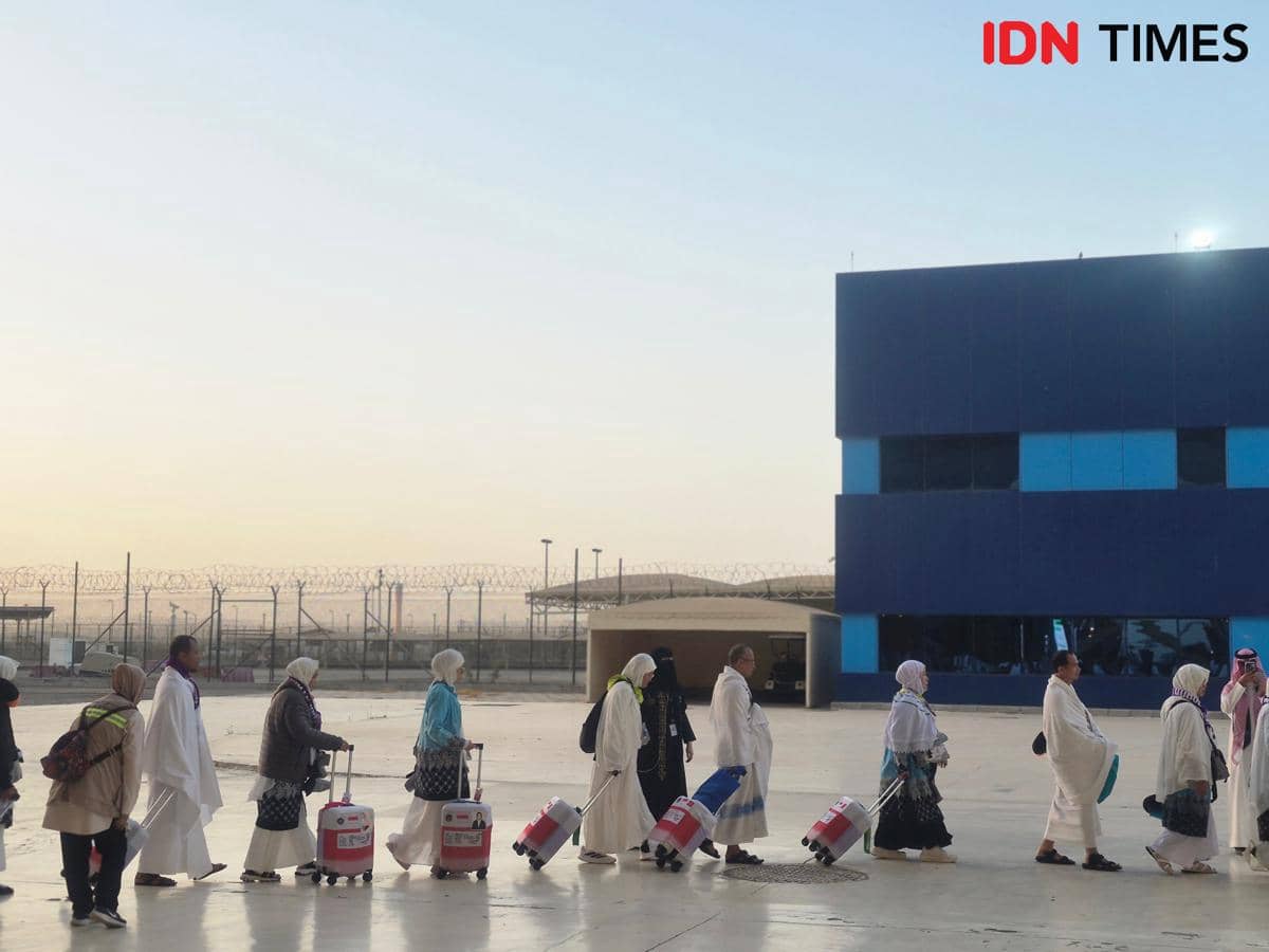 Rombongan jemaah haji embarkasi JKB 19 berjalan berbaris sambil membawa koper di Bandara Internasional King Abdul Aziz.