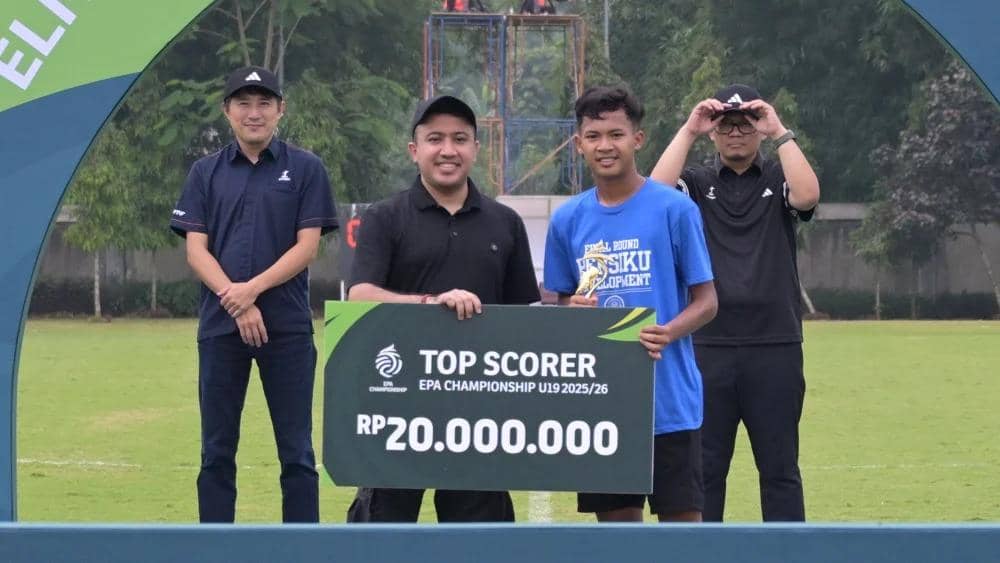 Seorang pemain muda menerima penghargaan top scorer EPA Championship U19 2025/26 dengan hadiah Rp20.000.000 di lapangan sepak bola.