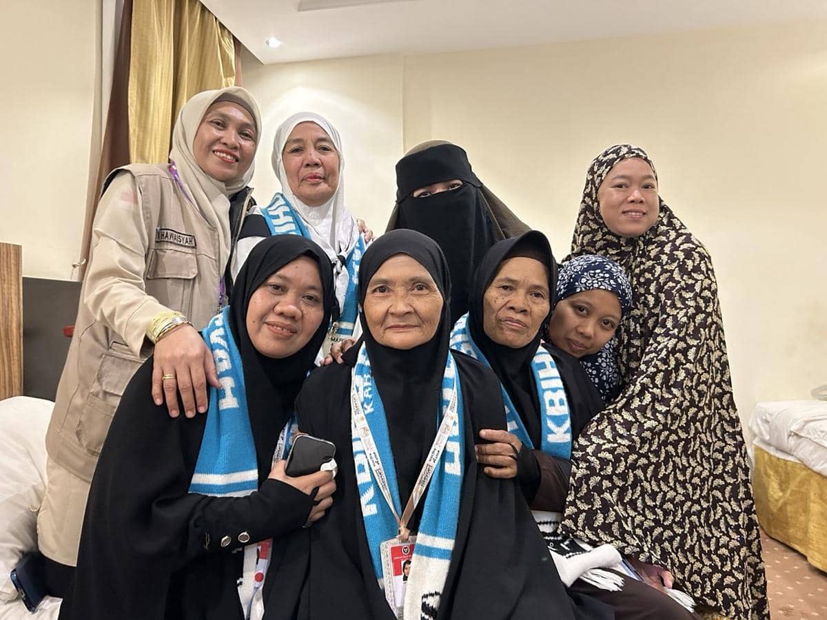 Seorang calon jemaah haji lanjut usia asal Maros berfoto bersama rombongan perempuan lainnya di sebuah kamar penginapan.