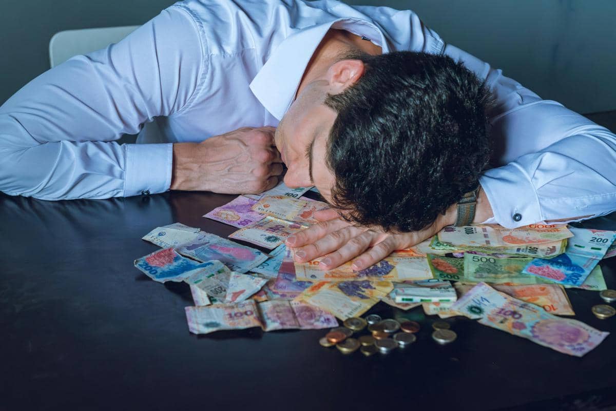 ilustrasi seorang pria tertidur di atas tumpukan uang, mencerminkan tekanan finansial sandwich generation
