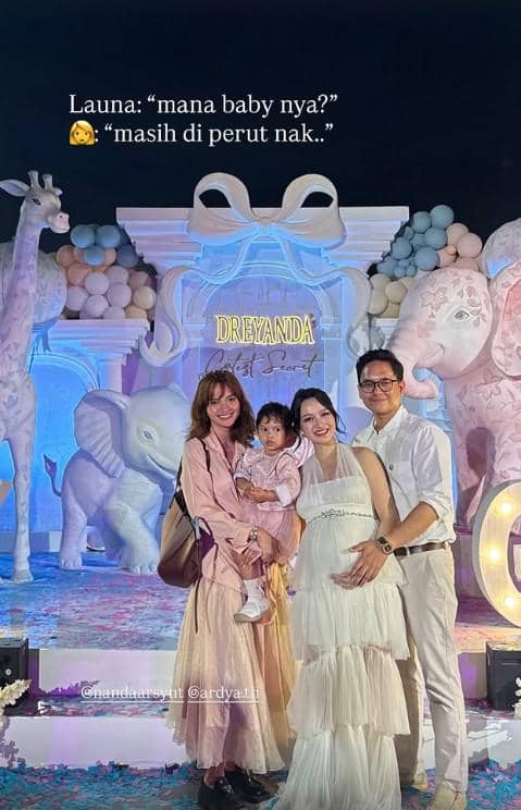Empat orang berpose di acara gender reveal bertema hewan dengan dekorasi pastel dan tulisan Dreyanda di latar belakang.