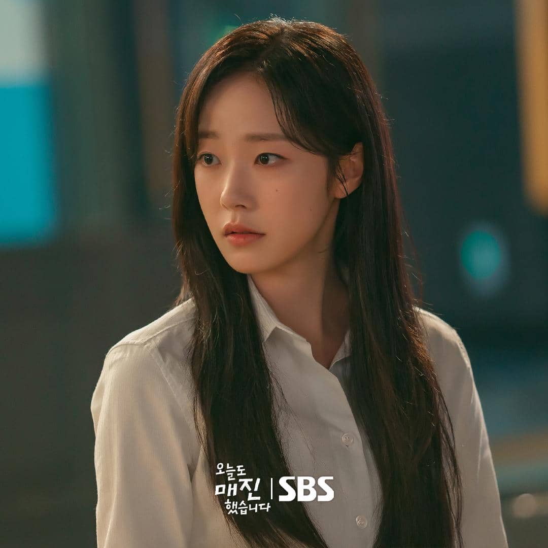 Seorang wanita berambut panjang mengenakan kemeja putih terlihat menatap ke samping dalam adegan drama Sold Out On You produksi SBS.