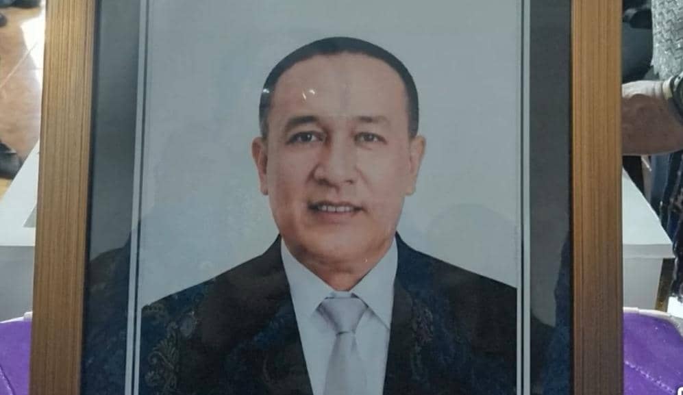 Potret pria berpakaian jas dan dasi berbingkai kayu yang dipajang dalam upacara penghormatan terakhir di Nusa Tenggara Timur.
