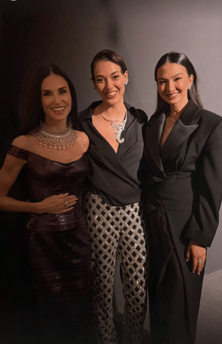 Tiga perempuan berpose bersama mengenakan busana elegan di acara Cannes Film Festival 2026 dengan latar gelap.