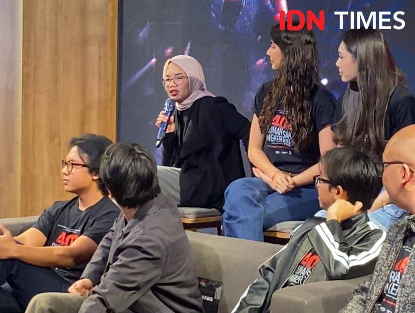 Beberapa orang duduk di atas panggung saat konferensi pers film 402 Rumah Sakit Angker Korea di MD Palace, salah satu pembicara memegang mikrofon.