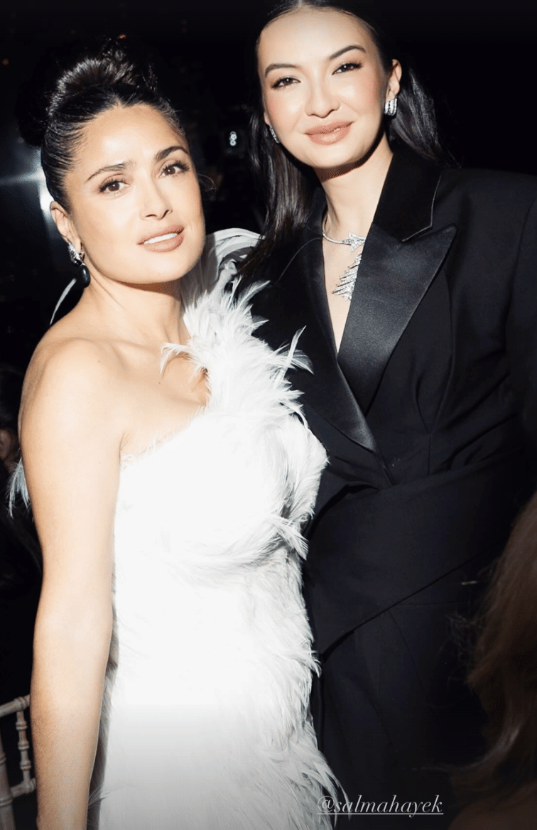 Dua perempuan berpose elegan di acara Cannes Film Festival 2026, satu mengenakan gaun putih berbulu dan satu mengenakan jas hitam.