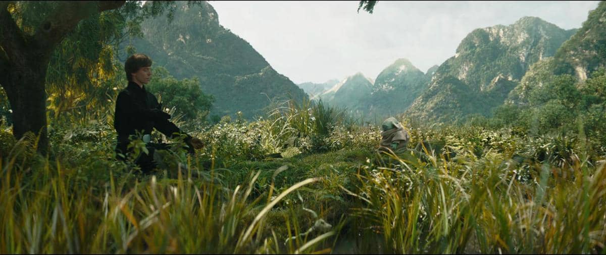 Luke Skywalker dan Grogu berada di tengah padang rumput hijau dengan latar pegunungan dalam adegan serial The Book of Boba Fett.