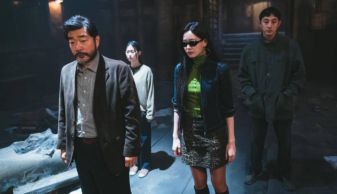 Empat karakter berdiri di ruangan gelap dengan suasana tegang dalam adegan drama The WONDERfools dari Netflix.