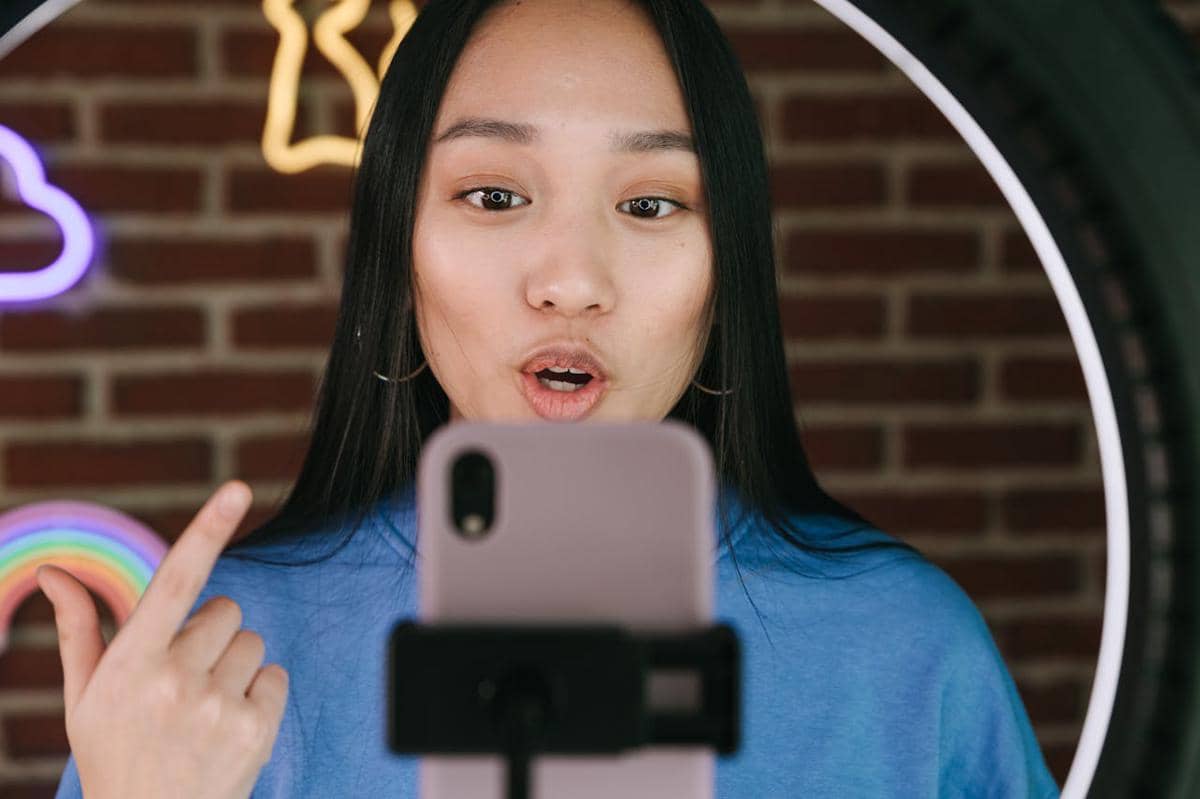 ilustrasi seorang wanita membuat vlog menggunakan ponsel