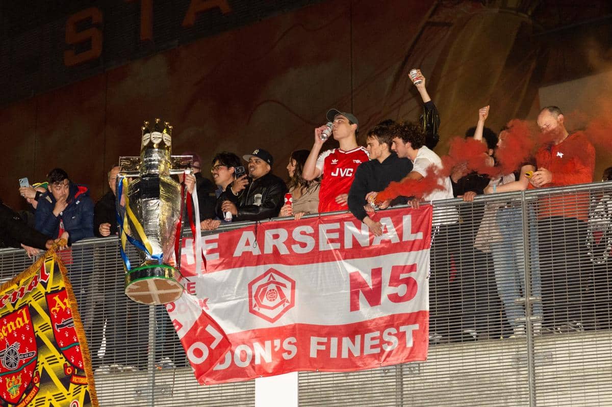 Salah satu suporter Arsenal menyindir selebrasi botol fan Manchester City saat merayakan gelar Premier League musim 2025/26 di Emirates Stad