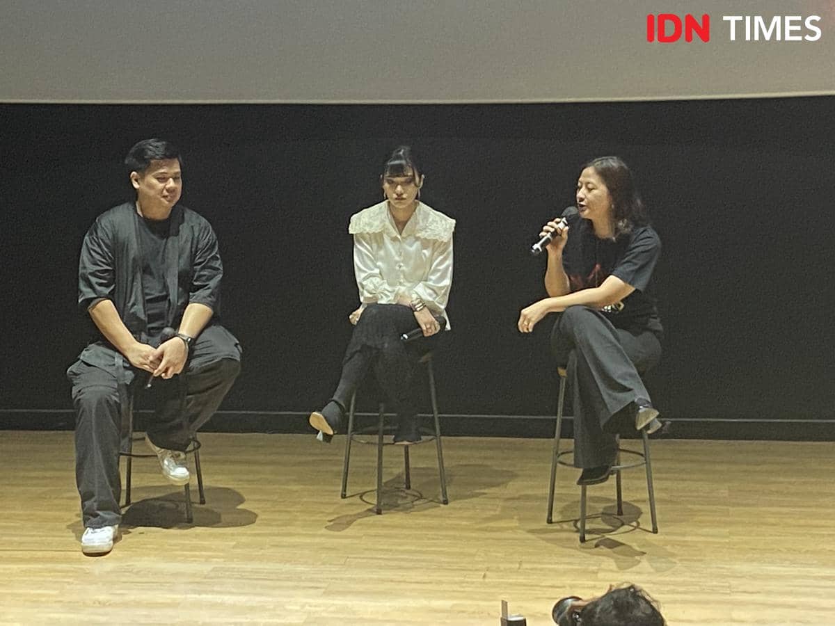 Tiga orang duduk di atas kursi tinggi di atas panggung saat acara Media Day album EKLEKTIKO di CGV fX Sudirman, berbincang santai.