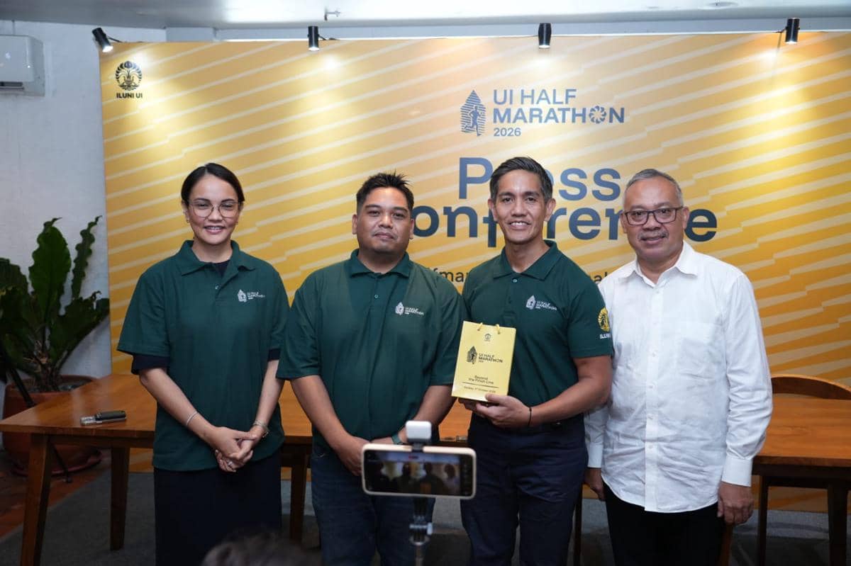 Empat perwakilan ILUNI UI berpose bersama dalam konferensi pers peluncuran UI Half Marathon 2026 dengan latar belakang kuning bertuliskan acara tersebut.