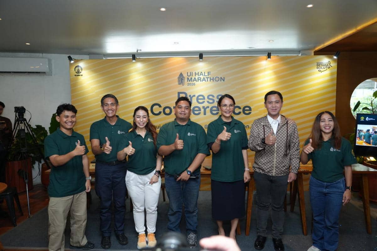 Sejumlah perwakilan ILUNI UI berpose bersama dengan latar belakang banner UI Half Marathon 2026 saat konferensi pers.