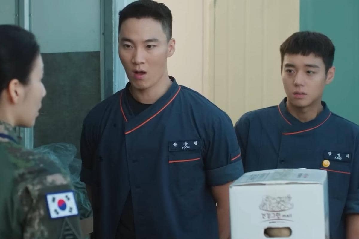 Dua pria berpakaian seragam dapur berbicara dengan seorang tentara wanita di sebuah ruangan dalam cuplikan drama The Legend of Kitchen Soldier.