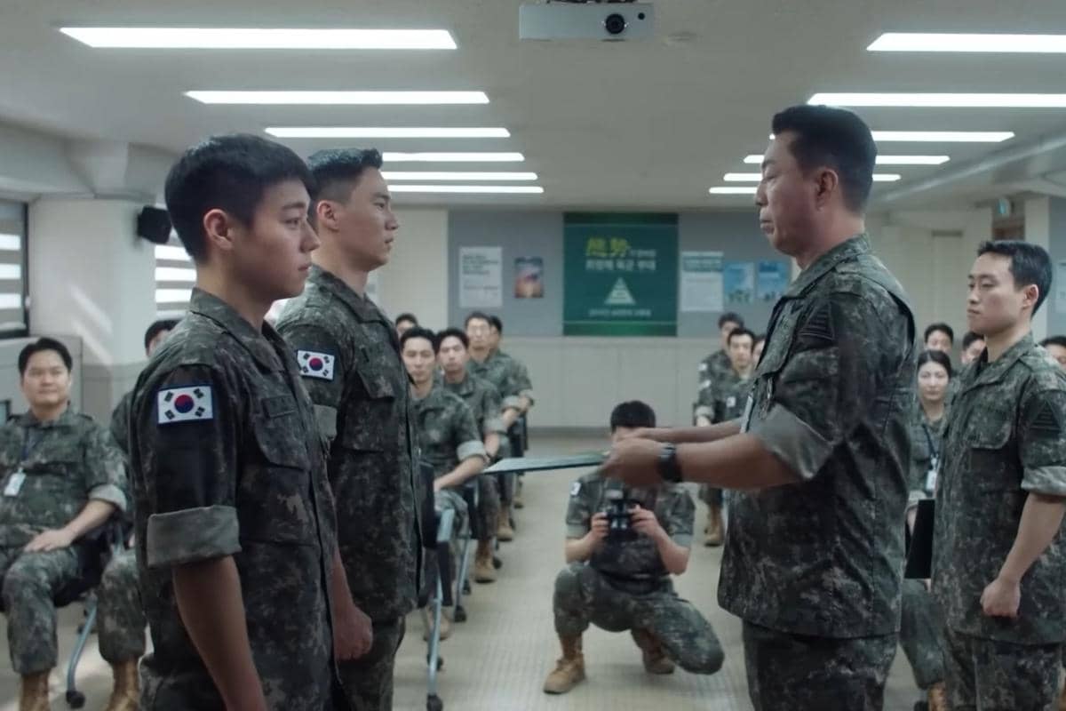 Beberapa tentara Korea Selatan mengenakan seragam militer sedang berdiri di ruangan pelatihan dalam adegan drama The Legend of Kitchen Soldier.