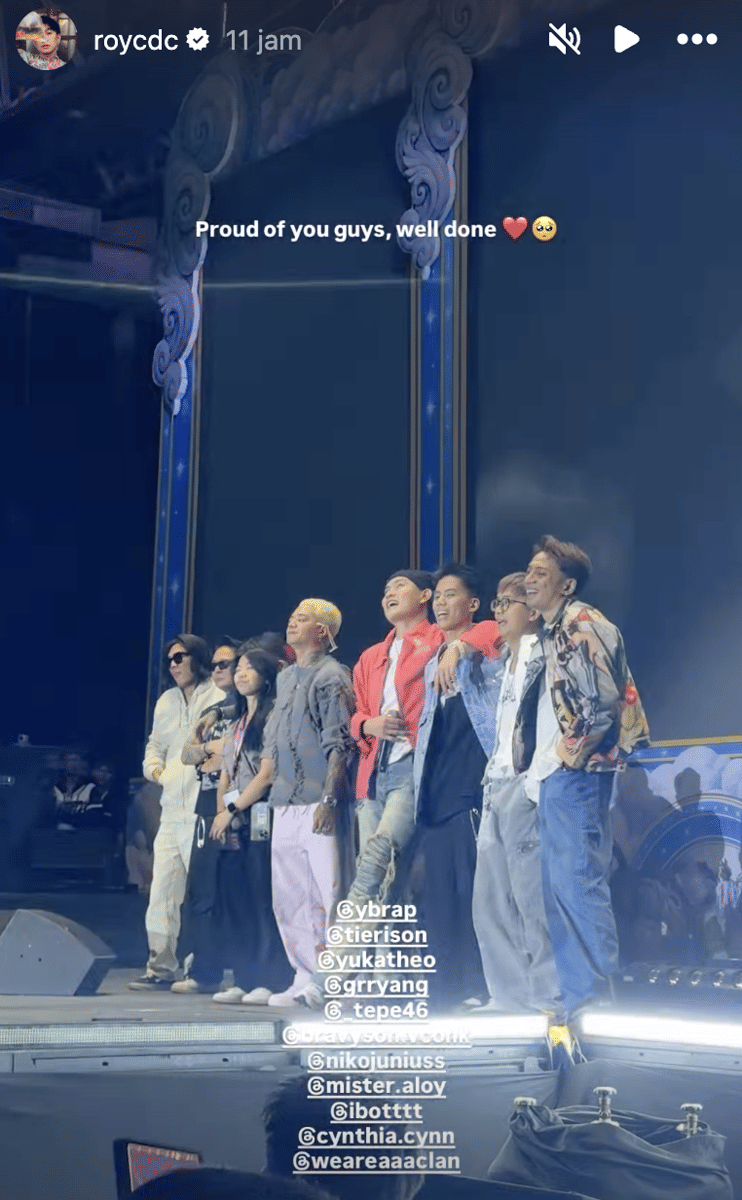 Sekelompok artis berdiri bersama di atas panggung Marapthon FestivAAAl dengan latar dekorasi biru dan pencahayaan panggung yang terang.