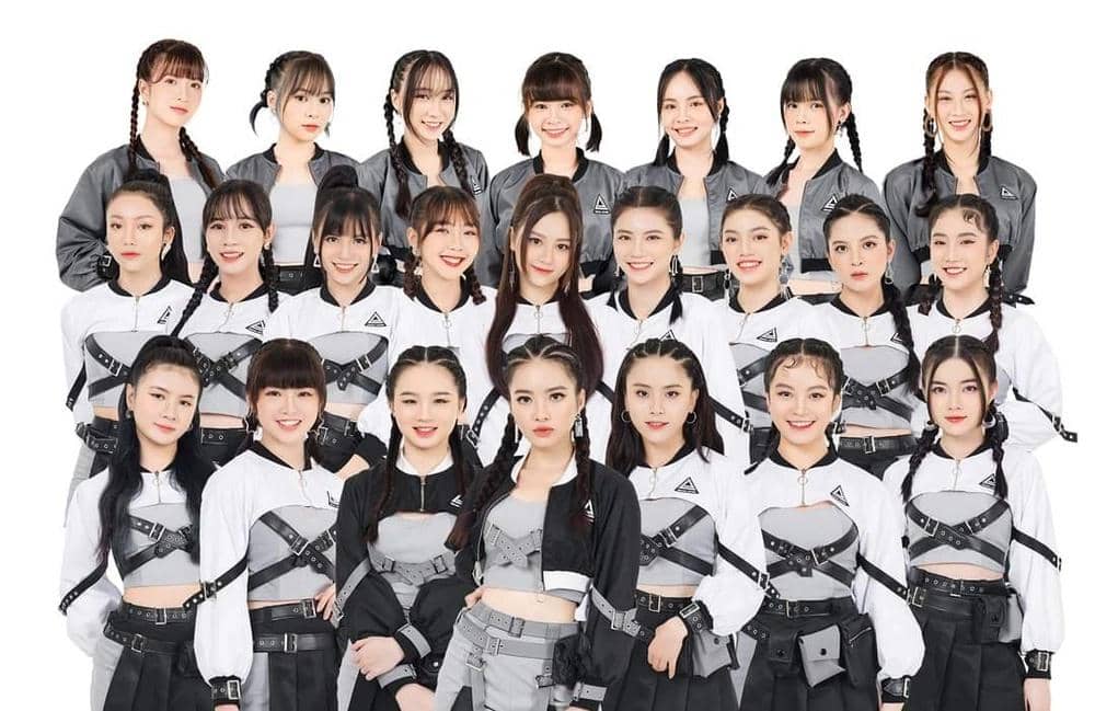 Grup idola wanita SGO48 berpose bersama mengenakan kostum hitam putih dengan gaya modern dan rambut dikepang.