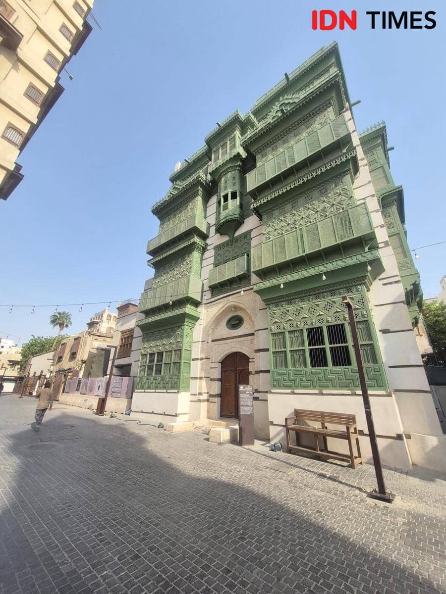 Bangunan Bayt Noorwali bergaya arsitektur Hijazi dengan jendela roshan berwarna hijau di kawasan bersejarah yang tenang.