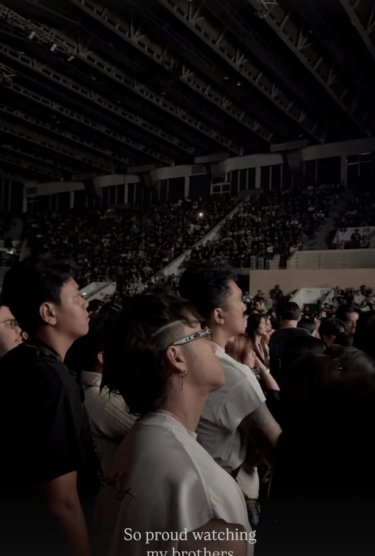 Penonton berdiri di dalam arena konser Marapthon FestivAAAl, menyaksikan pertunjukan dengan suasana ramai dan pencahayaan redup.