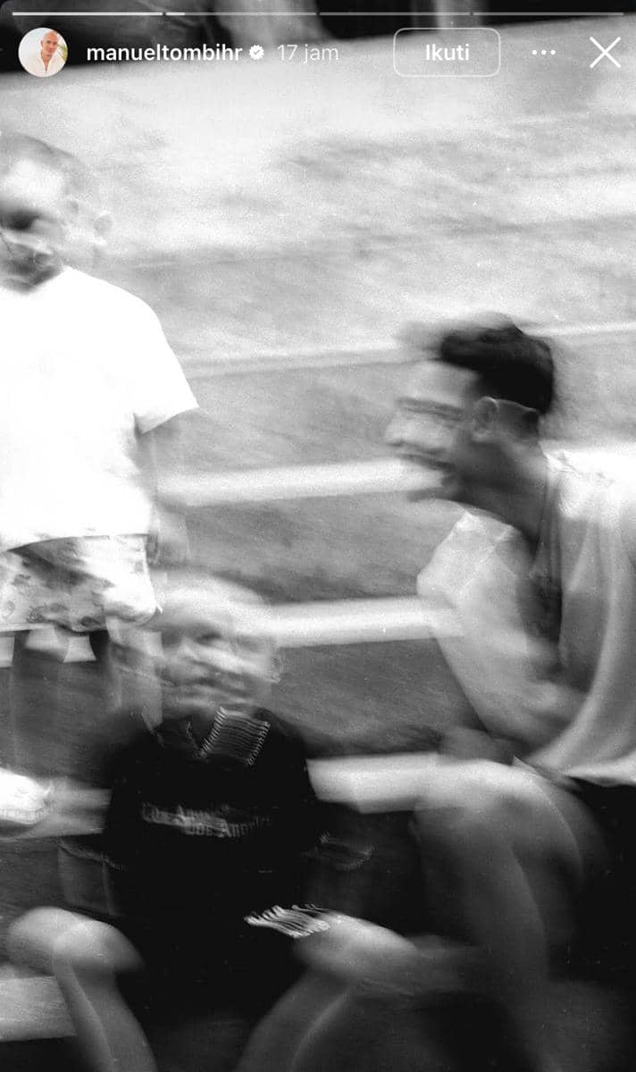 Potret hitam putih beberapa orang duduk dan berdiri di tangga dengan efek blur, diambil saat suasana santai di Bali.