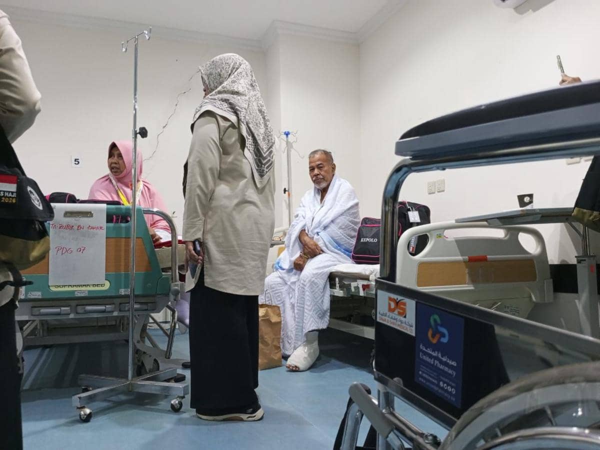 Petugas kesehatan membantu jemaah haji yang dirawat di ruang perawatan KKHI Madinah dengan peralatan medis di sekitarnya.
