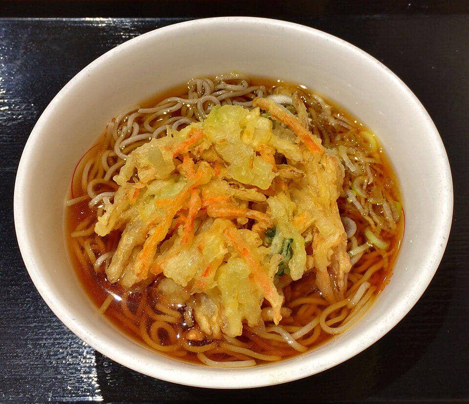 Semangkuk kakiage soba berisi mi soba dalam kuah kecokelatan dengan topping kakiage renyah dari sayuran goreng tepung.