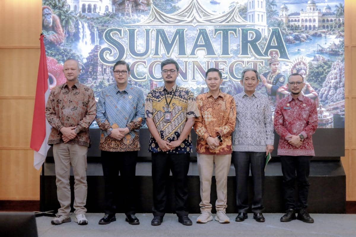 Enam pria berbusana batik berdiri berjajar di depan latar bertuliskan Sumatra Connect dengan bendera Indonesia di sisi kiri.