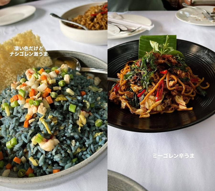 Dua hidangan khas Indonesia berupa nasi goreng berwarna biru dengan sayuran dan mi goreng pedas disajikan di atas meja makan.