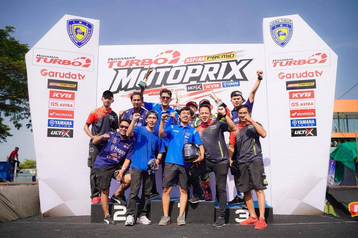 Tim balap merayakan kemenangan di podium Pertamax Turbo Motoprix dengan piala setelah sukses di race 2.