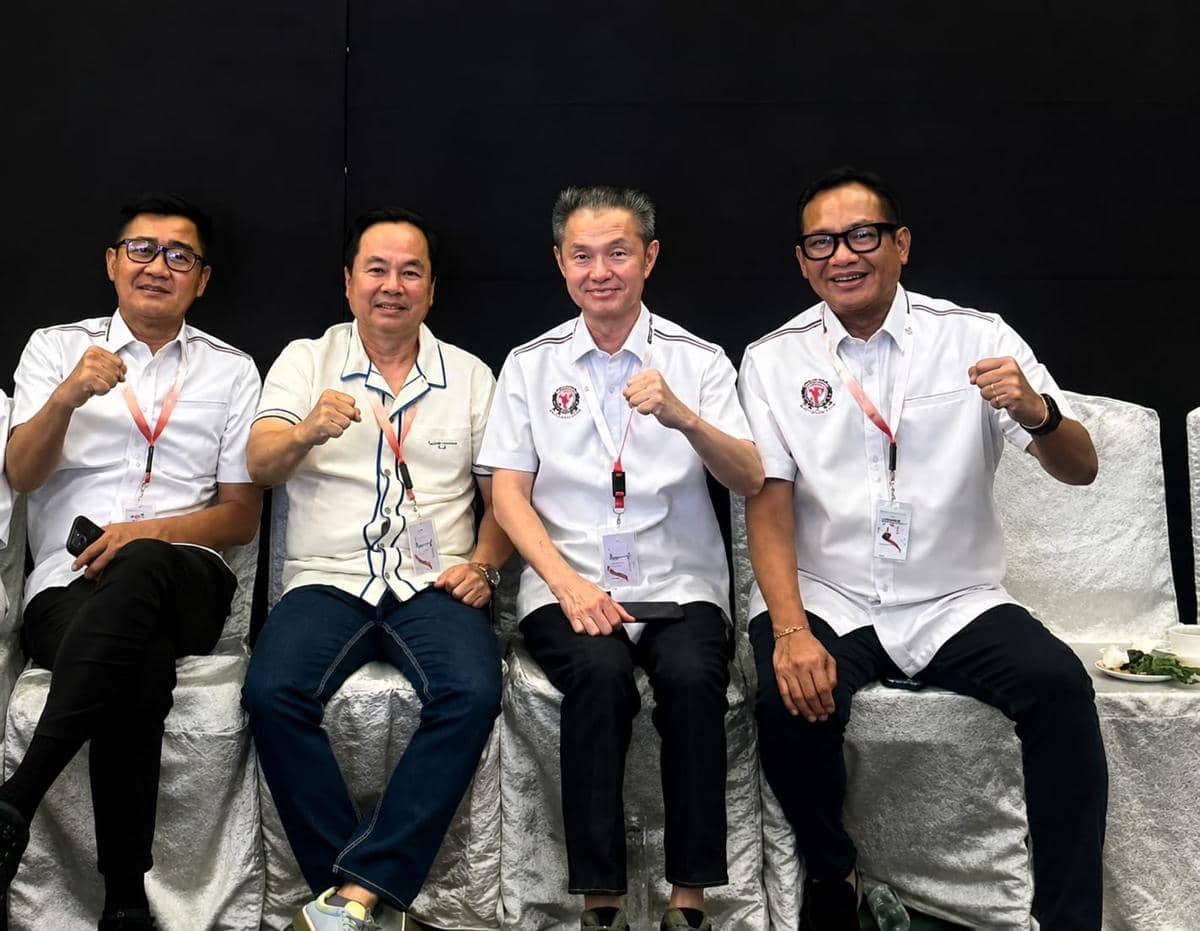 Empat pria duduk berdampingan mengenakan kemeja putih dan ID card, berpose dengan tangan mengepal dalam acara ORADO resmi menjadi anggota KONI.
