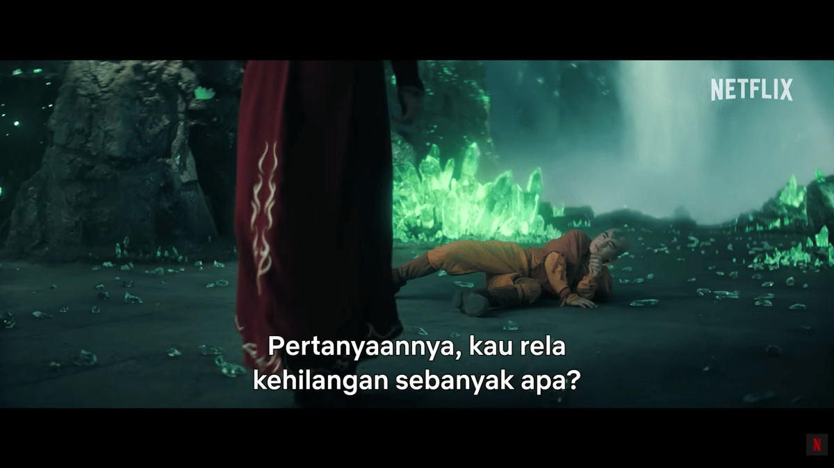 Aang terbaring di tanah dengan latar kristal hijau bercahaya saat Azula berdiri di depannya dalam adegan serial Netflix Avatar: The Last Airbender.