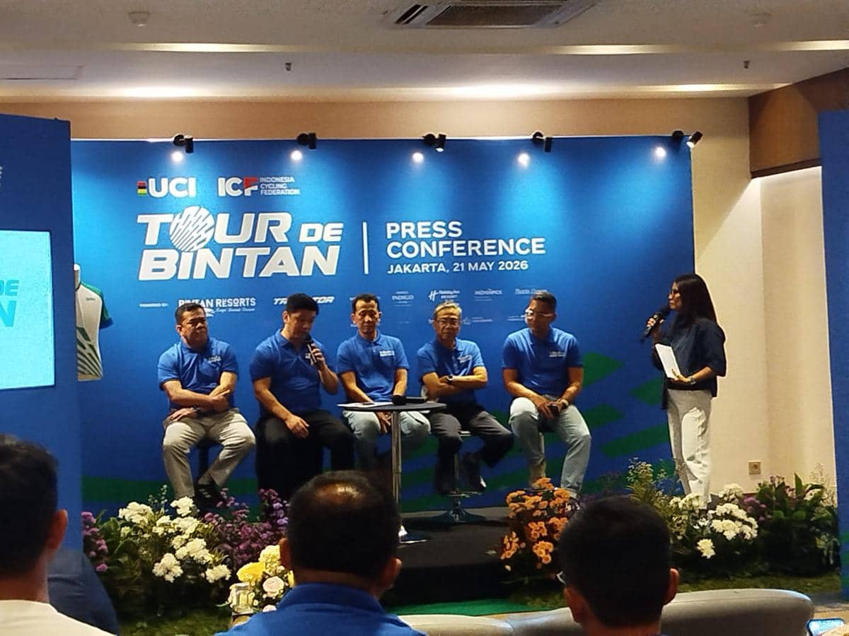 Konferensi pers Tour de Bintan 2026 di Jakarta dengan beberapa pembicara mengenakan kaus biru duduk di atas panggung.