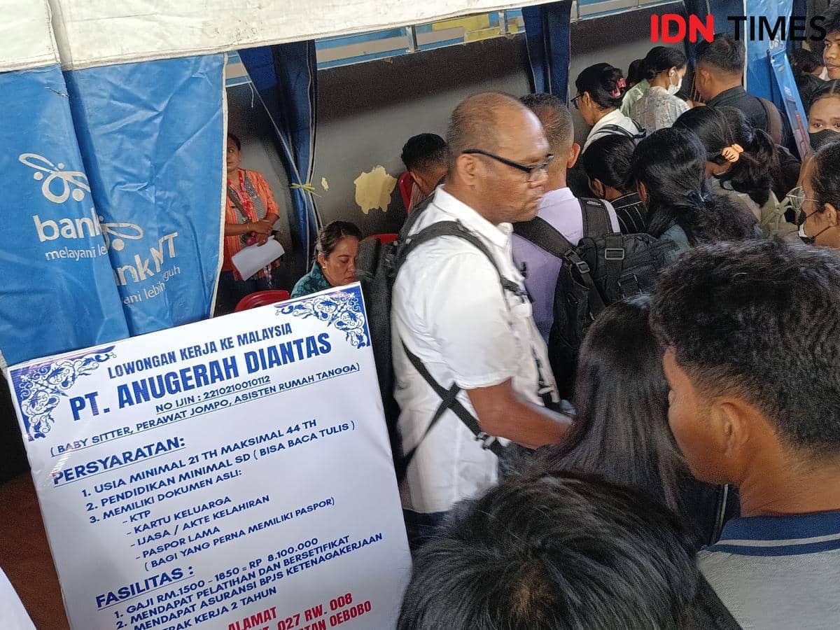 Sejumlah pencari kerja mengantre di stan perusahaan pada Job Fair NTT 2026 di Kupang dengan papan informasi lowongan kerja terlihat di depan.