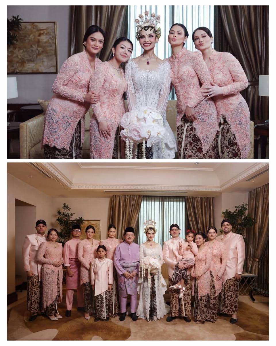 Pengantin wanita mengenakan kebaya putih dan siger Sunda berpose bersama keluarga dan pengiring mengenakan kebaya pink di acara pernikahan.